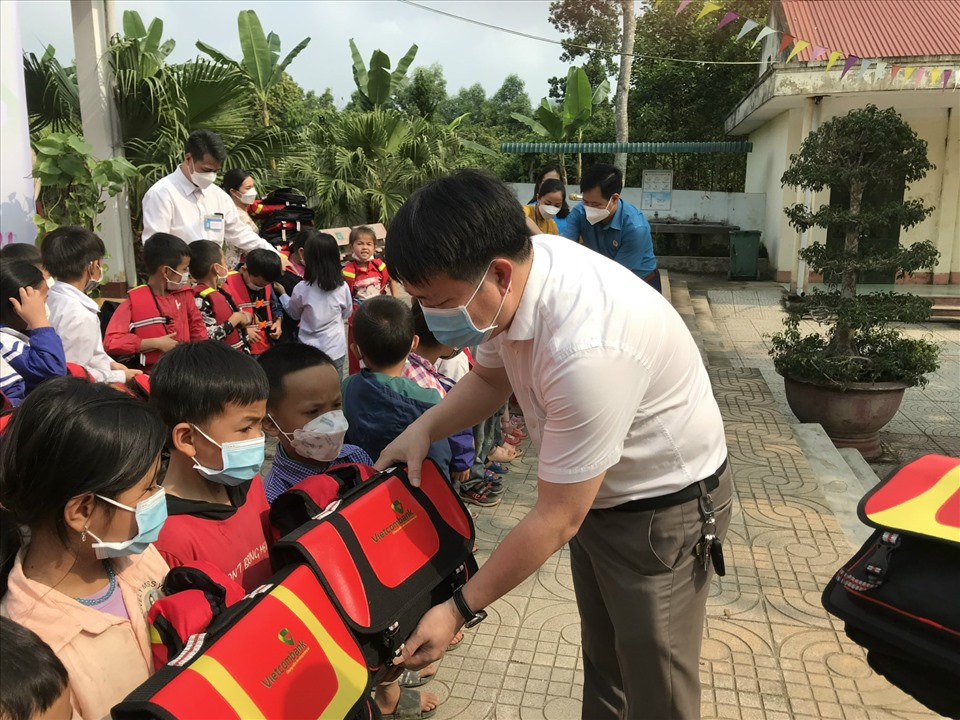 Nhà báo Nguyễn Xuân Hùng - đại diện Quỹ TLV Lao Động trao cặp phao cho học sinh. Ảnh: Thuý Hà