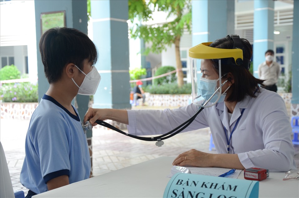 Học sinh được khám sàng lọc kỹ trước tiêm chủng. Ảnh: Huyên Nguyễn