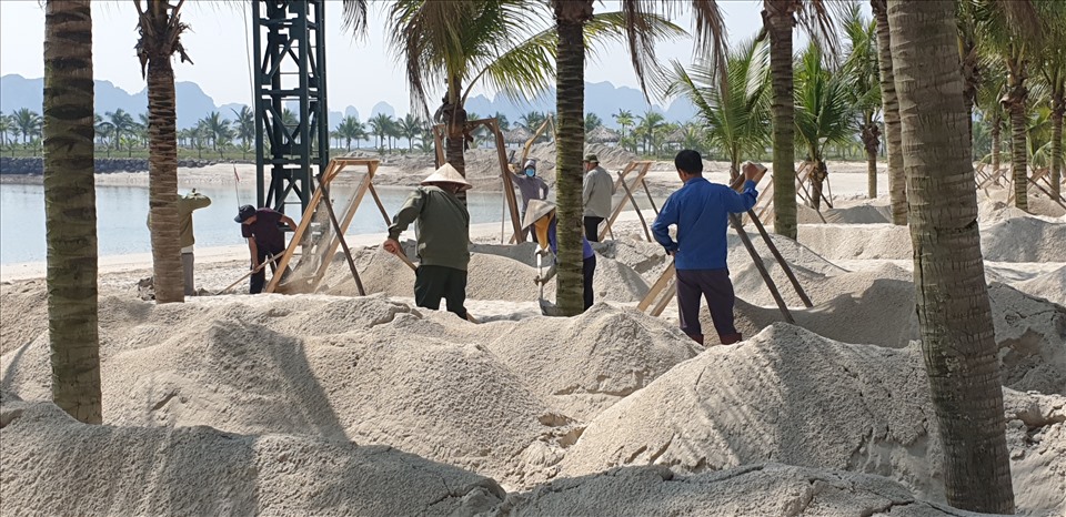 Lực lượng lao động sàng lọc cát để làm bãi thi đấu bóng chuyển bãi biển. Ảnh: Nguyễn Hùng
