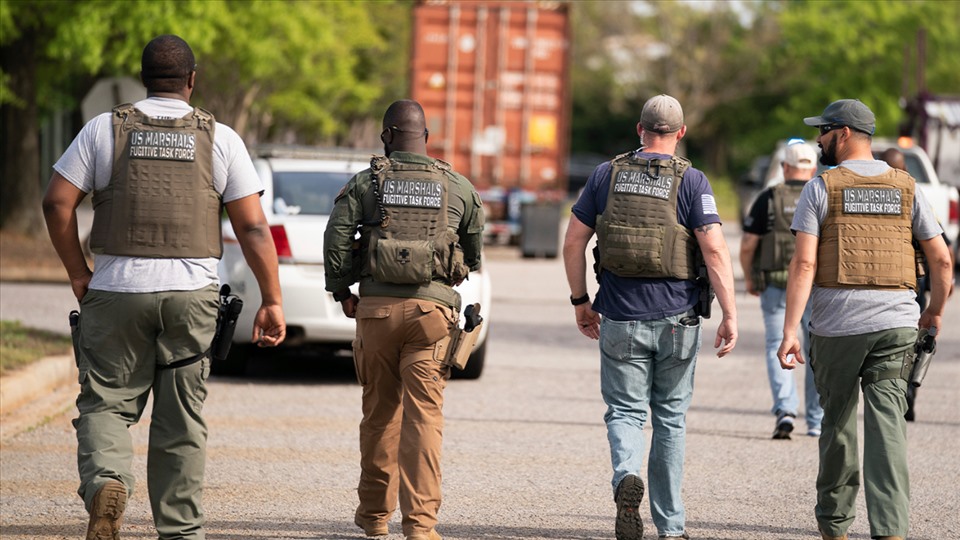 Law enforcement officers approach the scene of a shooting at the Columbiana Center on April 16.  Photo: AP