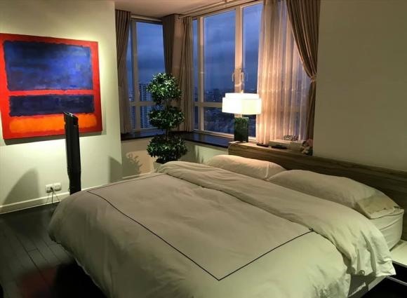 Phòng ngủ sang chảnh với thiết kế mang phong cách Châu Âu gồm có cây cảnh, tranh và cửa sổ lớn để ngắm nhìn thành phố.