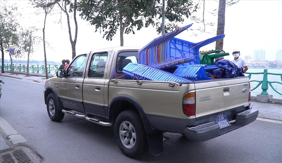 Lực lượng chức năng thu giữ các ghế nhựa của các hàng quán kinh doanh lấn chiếm vỉa hè hồ Tây. Ảnh: Quang Tùng.