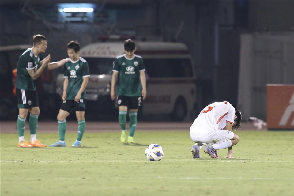 Cầu thủ Hoàng Anh Gia Lai đổ gục xuống sân trong khi các cầu thủ Jeonbuk ăn mừng bàn thắng.
