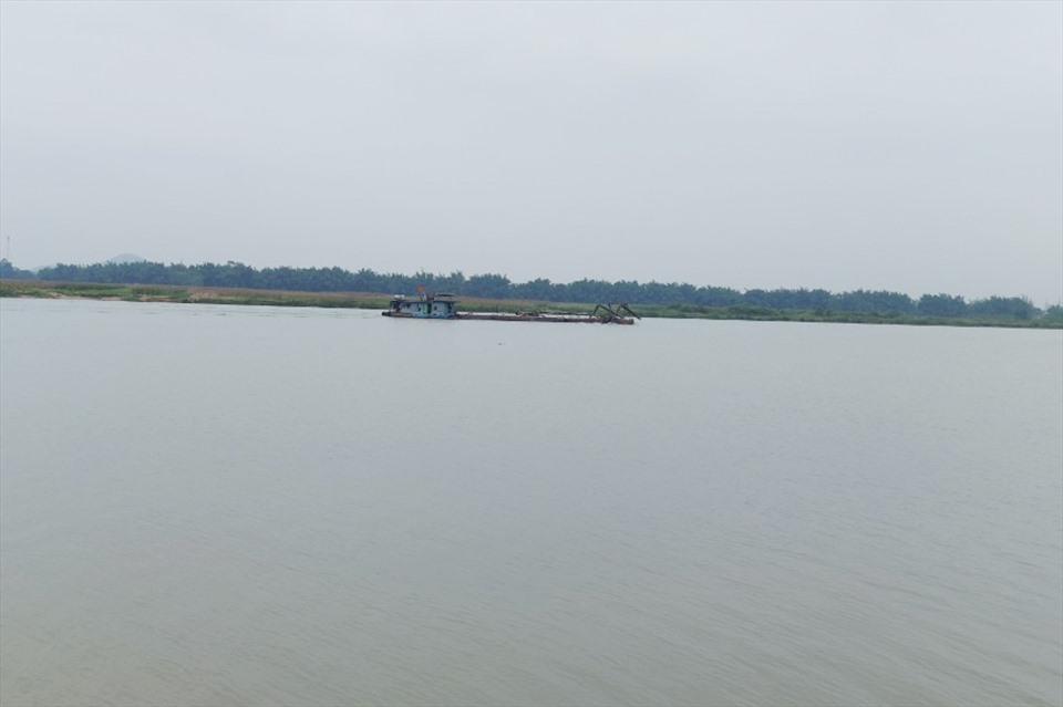 Một sà lan khai thác cát trên sông Lam đang đia qua khu vực sạt lở bờ sông đoạn thuộc xã Xuân Lam. Ảnh: TT.