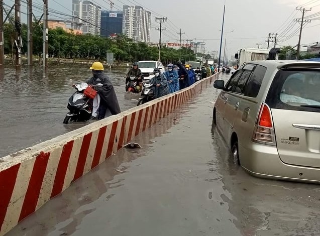 Đây là quốc lộ 13 - con đường huyết mạch của tỉnh Bình Dương trong cơn mưa chiều ngày 16.4. Hạ tầng của quốc lộ 13 đã không còn đáp ứng được yêu cầu của thực tiễn. Đường cống thoát nước quá nhỏ, mua lớn là xảy ra ngập cục bộ. Người lao động, phương tiện chở hàng vất vả lưu thông.