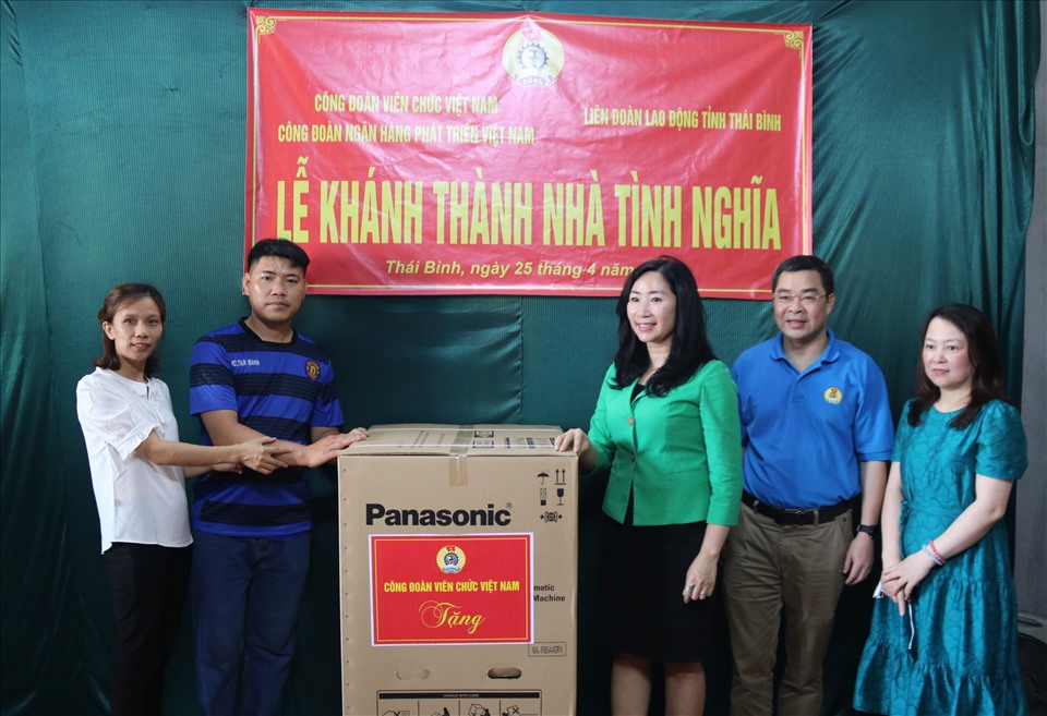 Lãnh đạo Công đoàn Viên chức Việt Nam, Công đoàn Ngân hàng phát triển Việt Nam tặng quà chúc mừng gia đình chị Trang. Ảnh: B.M