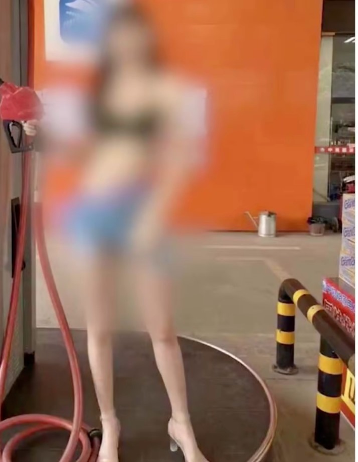 A girl in a bikini waits at a gas station in Qingdao.  screenshots