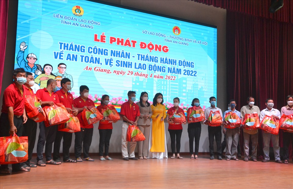 Đại diện lãnh đạo Đảng, UBND, HĐND, UBMTTQ Việt Nam tỉnh An Giang cùng đại diện các nhà tài trợ trao quà hỗ trợ người lao động có hoàn cảnh khó khăn. Ảnh: LT