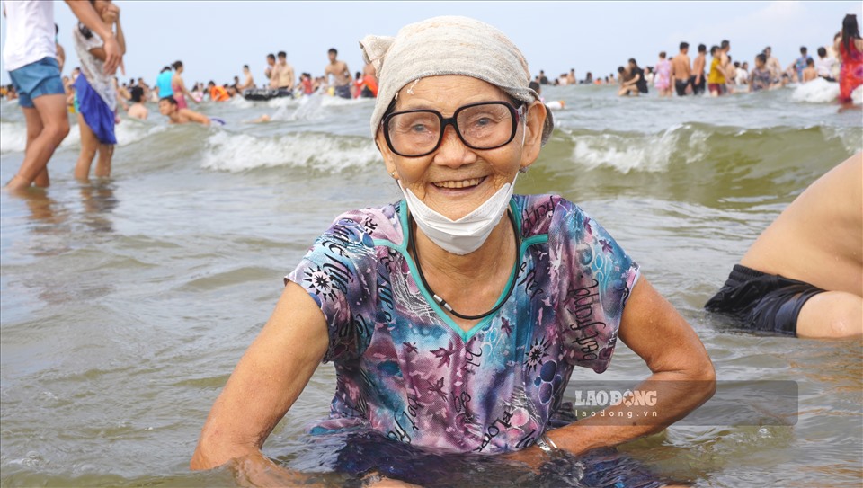 Cụ bà 82 tuổi (quê ở huyện Đông Sơn, Thanh Hóa) vui mừng khi được con cháu đưa về tắm mát tại bãi biển Sầm Sơn.
