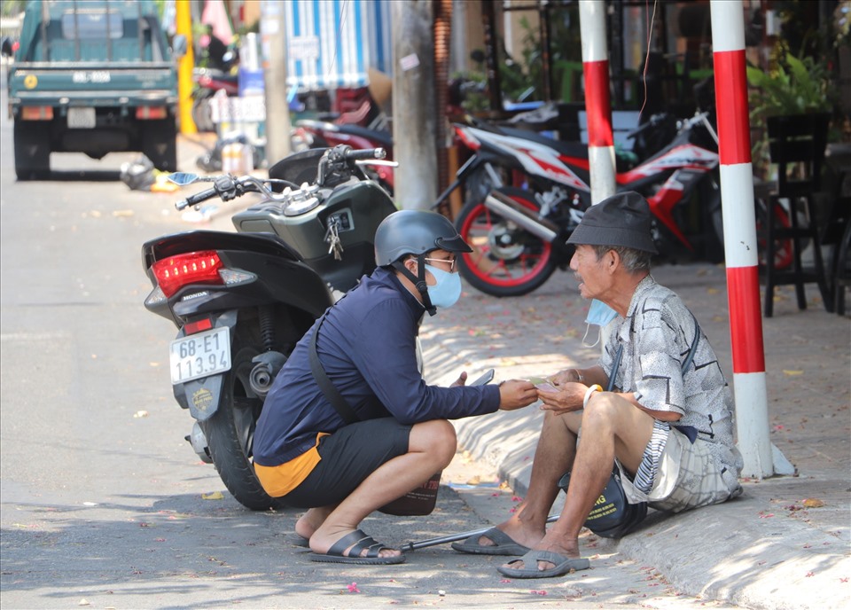 Chàng trai Ngôn Đức Thắng cho tiền để giúp người bán vé số dạo trong lúc khó khăn khi thực hiện giãn cách xã hội.