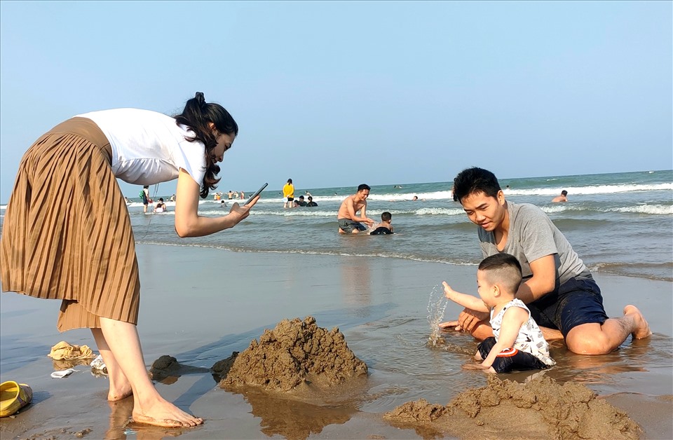 Nhiều gia đình đã cho con nhỏ cùng đi nghỉ mát và thỏa sức vui đùa trên bãi biển. Ảnh: Q.D