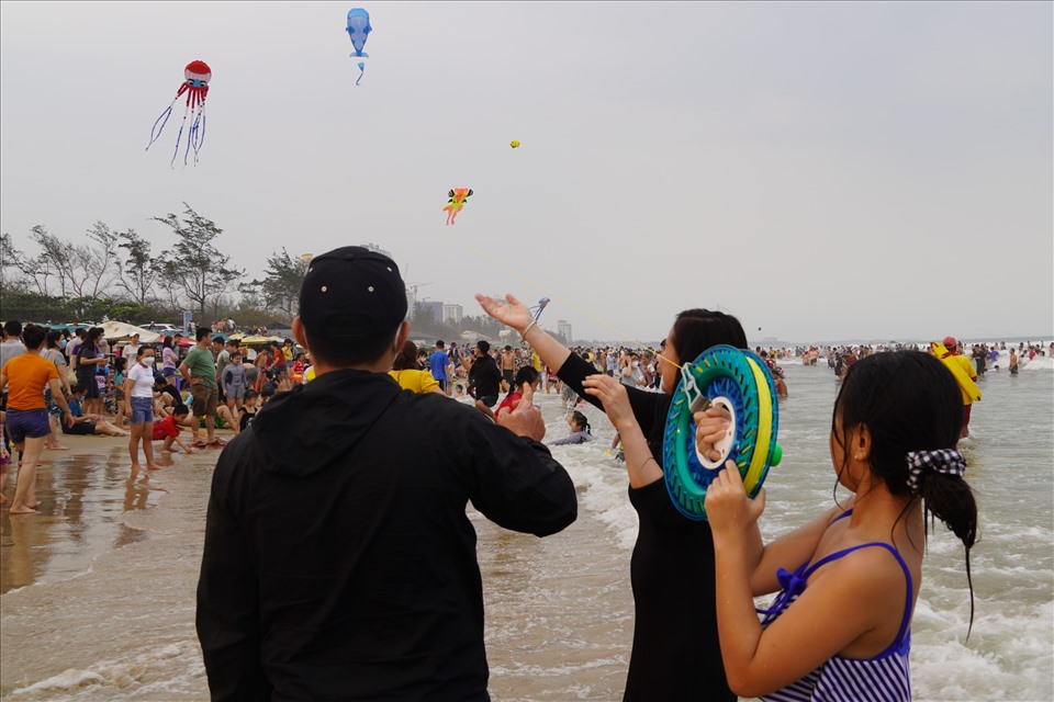 Với những luồng gió biển, nhiều du khách thích thú với trò chơi thả diều trên bãi tắm. Ảnh: T.A
