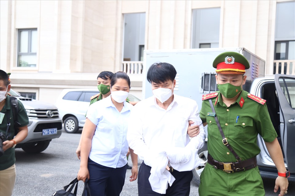 Khoảng 7h20, lực lượng cảnh sát dẫn giải ông Trương Quốc Cường (giữa) - cựu Thứ trưởng Y tế vào phòng xét xử. Ảnh: V.D