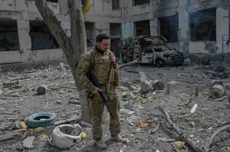 Một binh sĩ Ukraina đứng bên ngoài một trường học bị trúng tên lửa ở làng Zelenyi Hai giữa Kherson và Mykolaiv. Ảnh: AFP