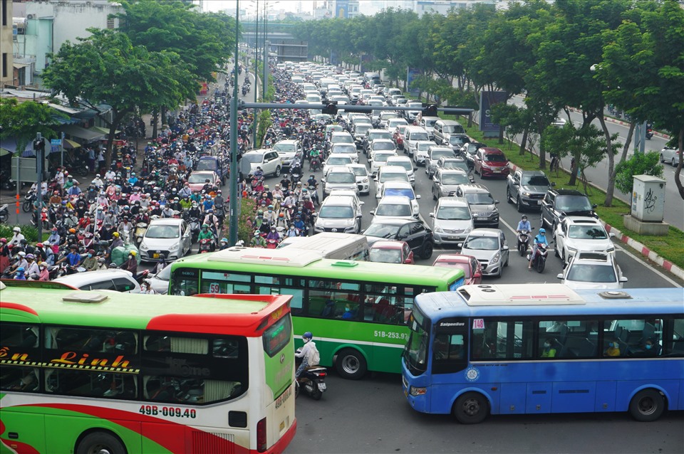 Xe cộ xếp hàng dài trên đường Phạm Văn Đồng do bị dòng xe từ Nguyễn Kiệm ra Nguyễn Thái Thái Sơn cắt ngang.