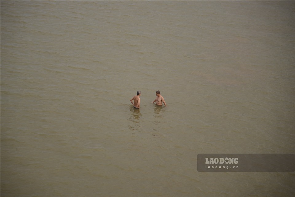 Người dân bơi giữa sông Hồng, không mặc đồ bảo hộ mặc dù đã có biển cấm bơi lội