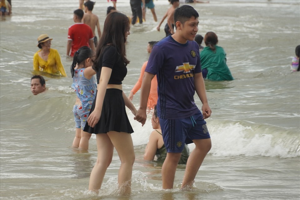 Dù trời âm u và chuyển mưa, nhiều người vẫn di chuyển xuống các bãi tắm để vui chơi, tắm biển trong ngày 2.5. Ảnh: T.A