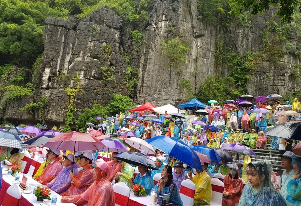 Hàng nghìn du khách “đội mưa” cùng trải nghiệm những hoạt động văn hóa, văn nghệ đặc sắc bên dòng sông Ngô Đồng thơ mộng. Ảnh: NT