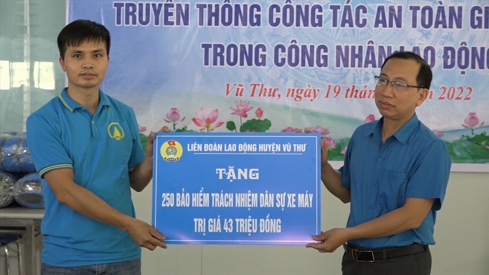 Ông Phạm Văn Trịnh (bên phải) - Chủ tịch LĐLĐ huyện Vũ Thư trao tặng thẻ bảo hiểm trách nhiệm dân sự xe máy cho đoàn viên, người lao động tại công ty TNHH Creative Souce Việt Nam. Ảnh: B.M