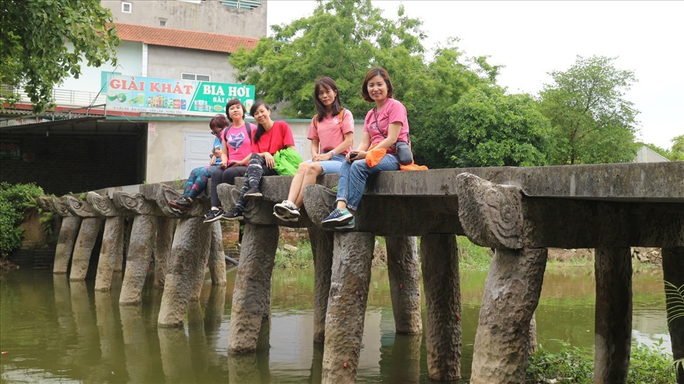 Cho những đôi chân nghỉ ngơi trên cây cầu đá cố ở làng Nôm. Ảnh: Nguyễn Hương