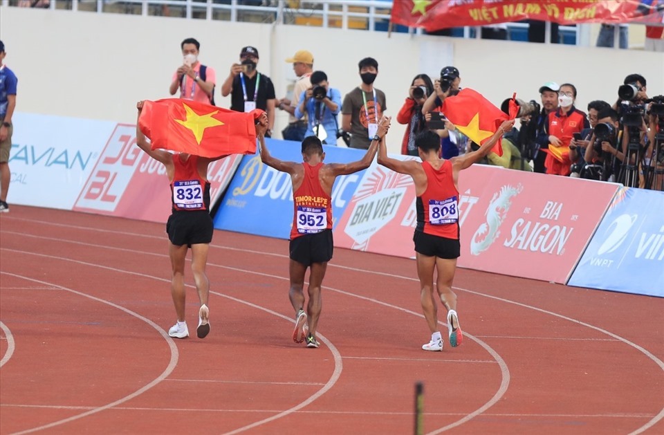 Felisberto ăn mừng cùng 2 vận động viên Việt Nam sau khi giành huy chương bạc nội dung 10.000m tại SEA Games 31. Ảnh: Thanh Vũ