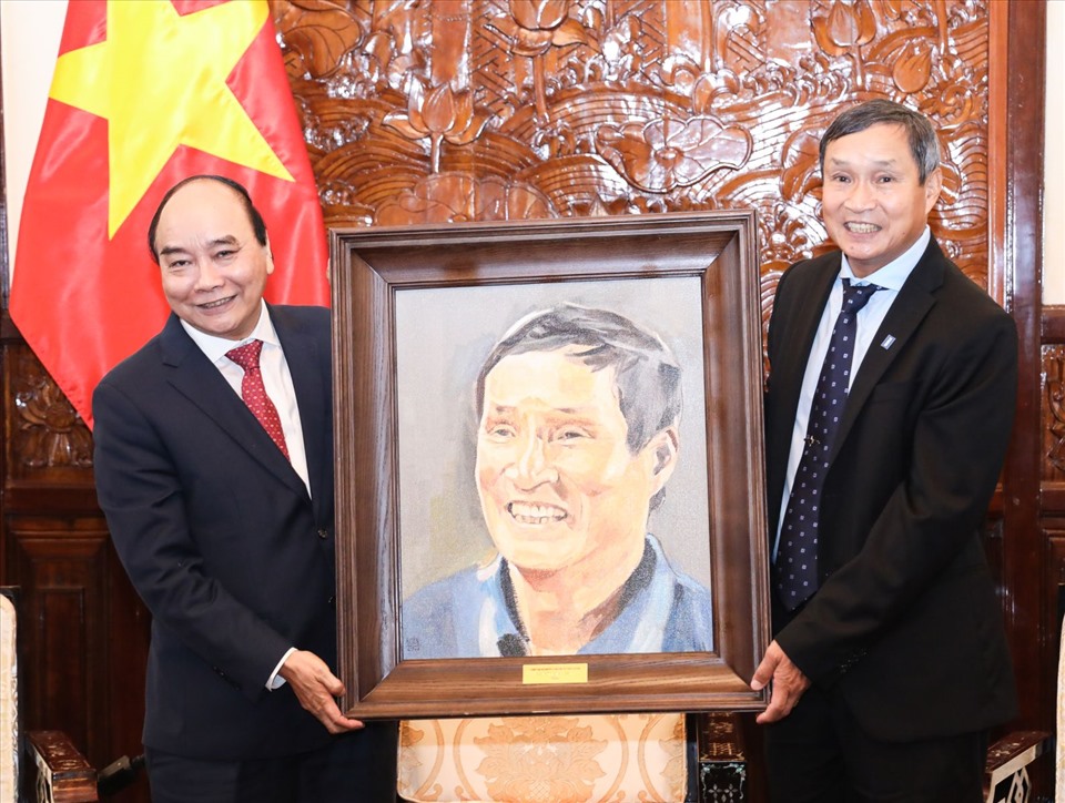 Chủ tịch nước Nguyễn Xuân Phúc tặng tranh lưu niệm HLV Đội tuyển bóng đá nữ SEA Games 31 Mai Đức Chung. Ảnh: VPCTN