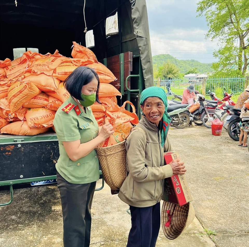 Nữ đoàn viên công đoàn Công an tỉnh Bình Thuận giúp người dân đặt bao gạo được tặng vào chiếc gùi. Ảnh: CTV