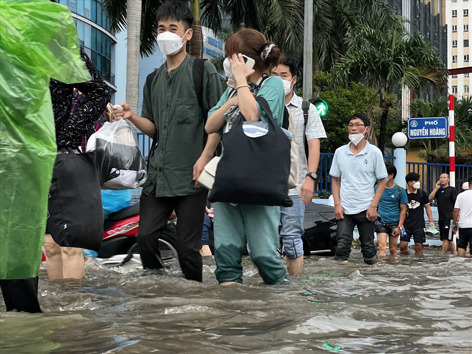 Mưa lớn đã dứt nhưng nước vẫn chưa rút khiến nhiều người dân không thể di chuyển bằng các phương tiện giao thông mà phải đi bộ.