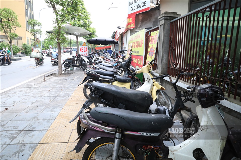 Dãy xe máy hư hỏng xếp hàng chờ tới lượt sửa trên đường Dương Đình Nghệ (Cầu Giấy).