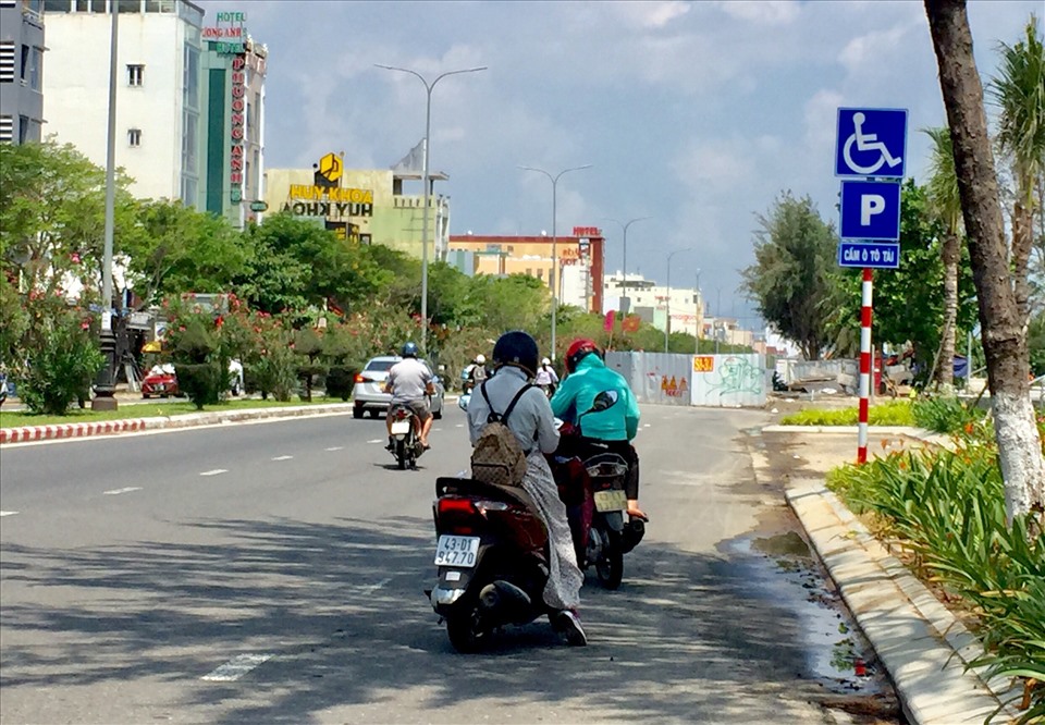 Người dân mặc áo chống nắng, bịt kín khẩu trang, đeo kính râm... khi tham gia giao thông trên đường. Ảnh: Nguyễn Linh
