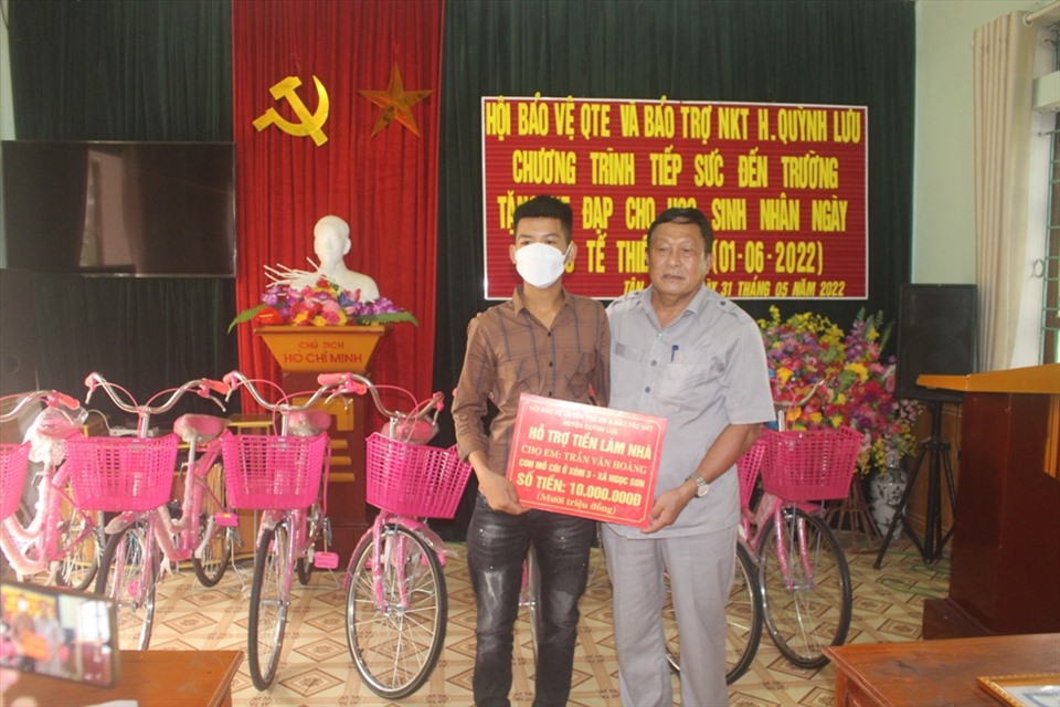 ông Dương Danh Hòa - Chủ tịch Hội Bảo vệ quyền trẻ em và Bảo trợ NKT huyện Quỳnh Lưu trao tiền hỗ trợ làm nhà cho trẻ em mồ côi xã Ngọc Sơn. Ảnh: MK