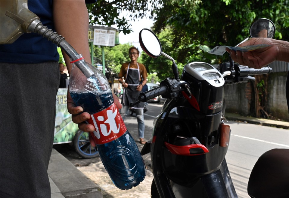 Đem chai đi mua xăng ở Jakarta, Indonesia ngày 29.5.2022. Ảnh: AFP