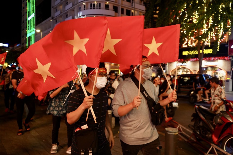 Những lá cờ đỏ sao vàng trên tay người hâm mộ tung bay giữa phố đi bộ Nguyễn Huệ.