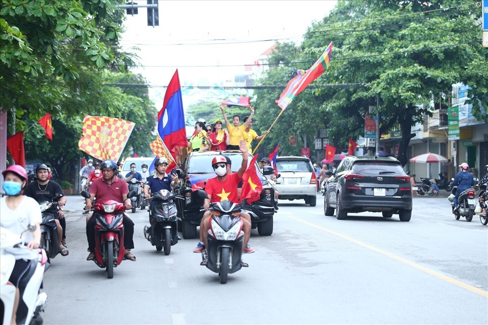 Cổ động viên Nam Định diễu hành lá cờ Lào vòng quanh thành phố Nam Định. Ảnh: A.N