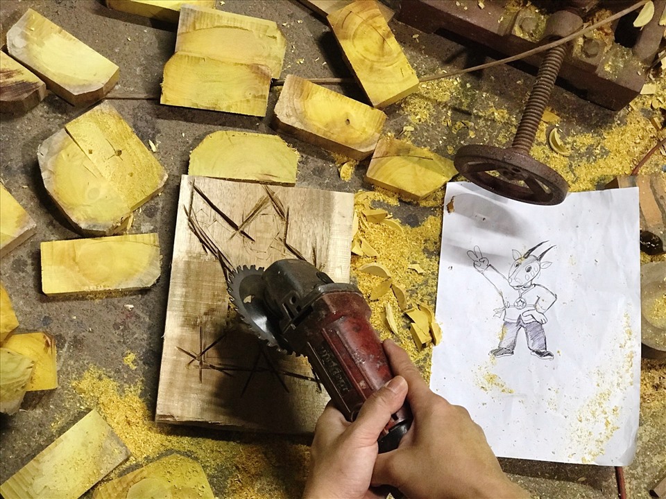 Nghệ nhân cắt gỗ theo bản phác thảo trên giấy. Ảnh: Nguyễn Thúy.