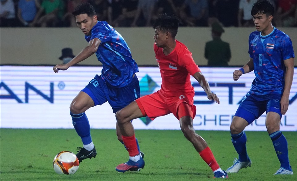 U23 Thái Lan (áo xanh) bước vào trận đấu thứ 2 SEA Games 31 khi hứng chịu sức ép lớn sau trận thua U23 Malaysia 1-2. Họ buộc phải thắng U23 Singapore mới có cơ hội để đi tiếp vào bán kết. Với mục tiêu này, huấn luyện viên Alexandre Polking tung ra sân đội hình xuất phát mạnh nhất có thể.