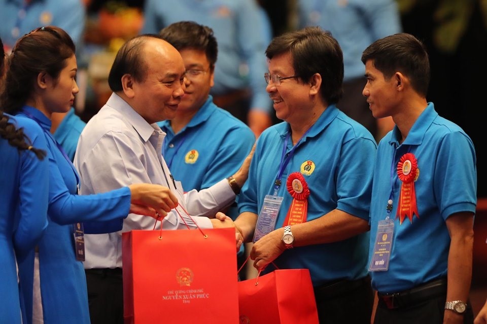 Thủ tướng Chính phủ Nguyễn Xuân Phúc (nay là Chủ tịch nước Nguyễn Xuân Phúc) trao quà cho công nhân tiêu biểu. Ảnh: Sơn Tùng