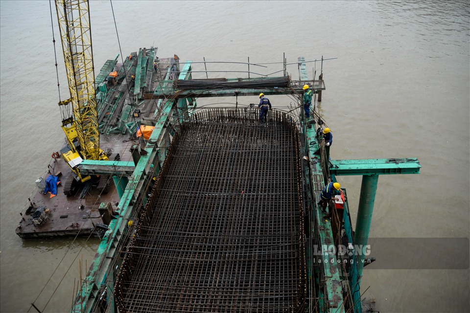Các công nhân đang tiến hành tạo khung thép cho phần trụ chống cầu để sau đó tiến hành đổ bê tông các trụ cầu dưới lòng sông Hồng.