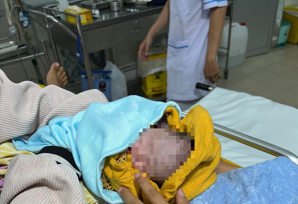 Em bé trong vòng tay mẹ sau khi đưa đến bệnh viện an toàn. Ảnh: DT