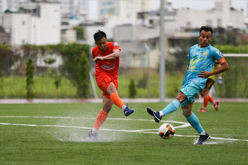 Lamy Land (áo xanh) và Liên Thành - An Lộc Phát thi đấu dưới cơn mưa nặng hạt. Ảnh: Dũng Phương