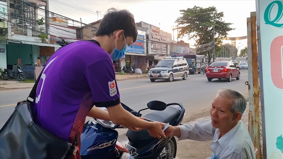 Trịnh Phú Quí lễ phép nhận tiền của khách mua vé số (Ảnh: Văn Sỹ)