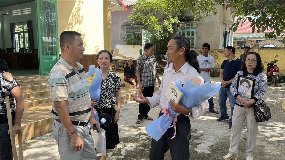 Ông Võ Ngọc (ôm bó hoa) trò chuyện cùng anh Đỗ Thanh An (con trai của nạn nhân) sau buổi công khai xin lỗi. Ảnh: DT