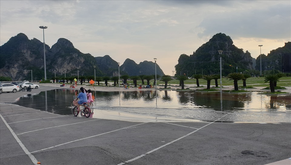 Trẻ em thích thú đạp xe ở khu vực bị nước biển tràn vào trong Quảng trường 30.10. Ảnh: Nguyễn Hùng