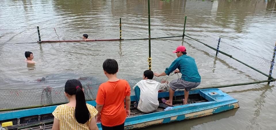 Những tình nguyện viên của xã đoàn tự mình xây hồ bơi “dã chiến” ngay bến sông để các em học bơi. Ảnh: PV