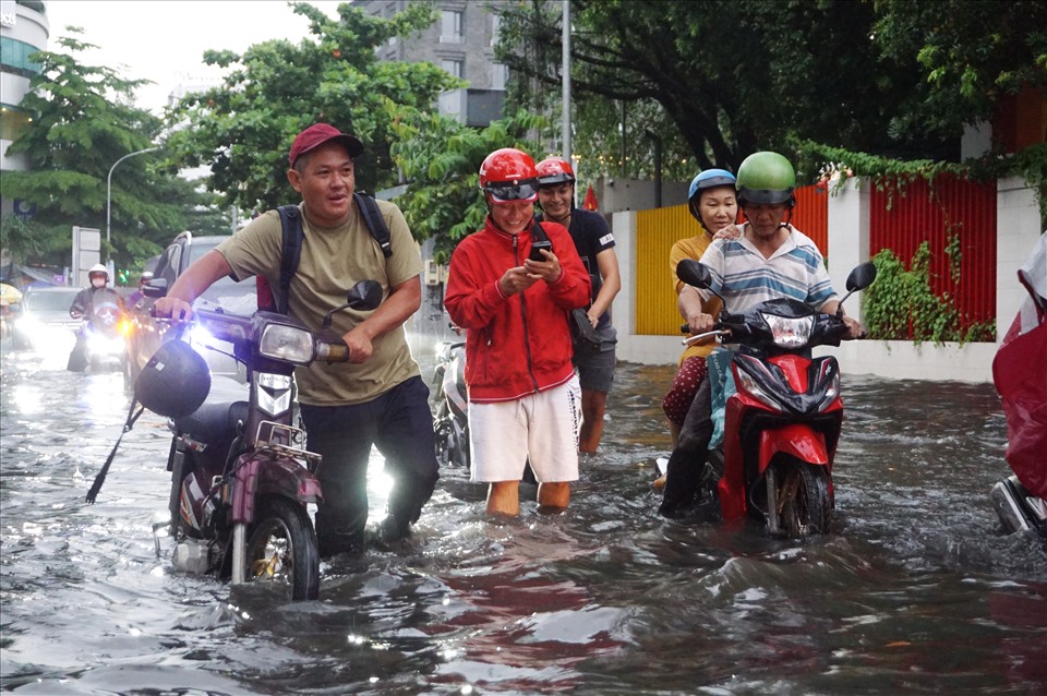 Theo người dân trên đường Quốc Hương, sau mưa 15 phút, đoạn đường bị ngập sâu khoảng 40 cm khiến nhiều xe chết máy. Người dân lội bị bõm dưới dắt xe dưới dòng nước đen ngòm.