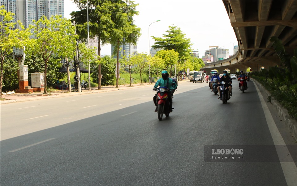 Để đối phó với cái nắng, nhiều người đi xe máy chuyển hẳn vào làn ô tô trên đường Phạm Hùng bất chấp nguy hiểm.