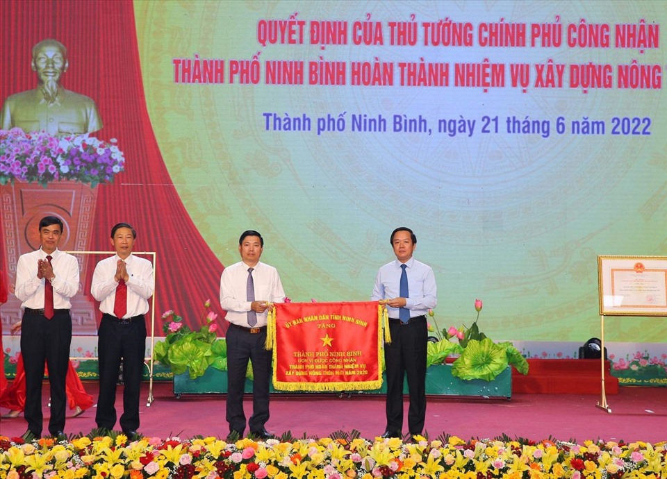 Ông Phạm Quang Ngọc - Chủ tịch UBND tỉnh Ninh Bình trao Cờ thi đua Xuất sắc của UBND tỉnh Ninh Bình cho cán bộ và nhân dân thành phố Ninh Bình. Ảnh: NT