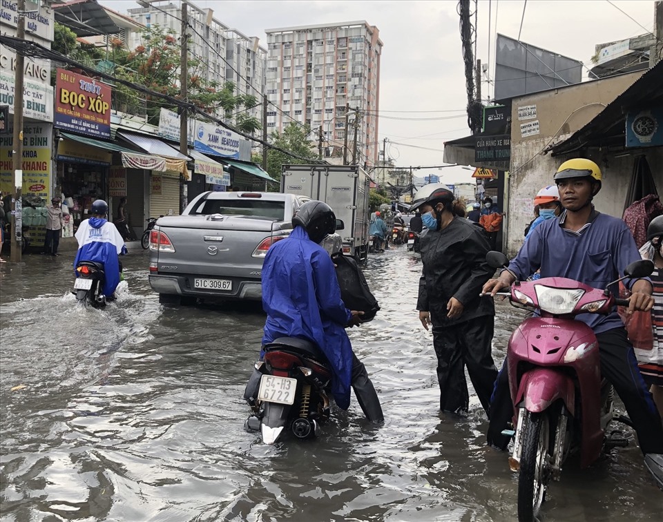 Mưa lớn kéo dài, người dân đi làm về phải bì bõm dắt xe lội nước do phương tiện chết máy.