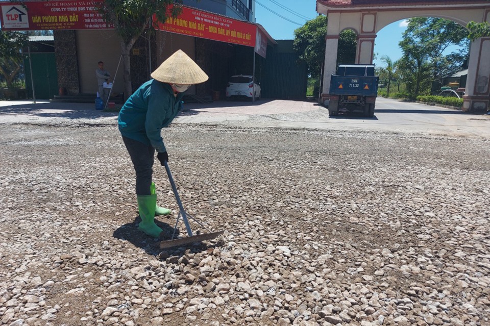 Đã hơn 11h trưa mà người phụ nữ này vẫn đang san gạt đá để làm mặt bằng tại công trình làm đường giao thông ở xã Thạch Hạ, thành phố Hà Tĩnh. Ảnh: Trần Tuấn.