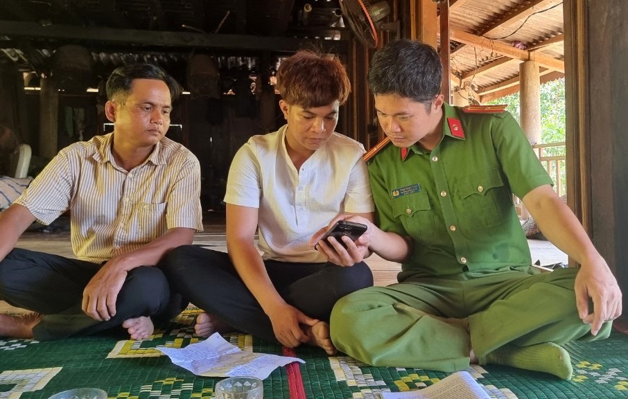 Cậu của T. (giữa ảnh) cung cấp các hình ảnh, video do T. quay lại ở nơi đang bị giữ tại Campuchia cho cán bộ công an. Ảnh: Hưng Thơ.